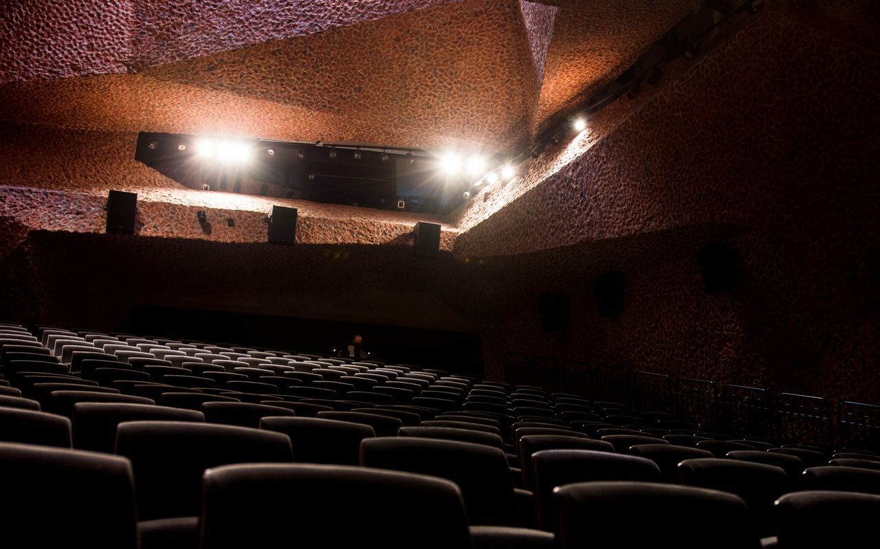 indoors, chair, illuminated, in a row, empty, architecture, repetition, built structure, absence, lighting equipment, large group of objects, seat, abundance, order, night, arrangement, window, no people, side by side, ceiling