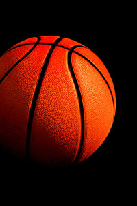 Close-up of basketball hoop against black background