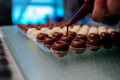 Hand filling pralines with chocolate