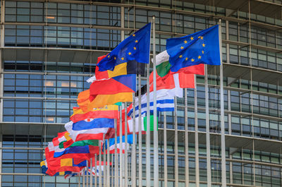 Low angle view of flags against modern building