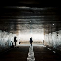 Rear view of people walking on illuminated walkway