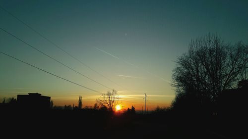 Illuminated trees against sky during sunset