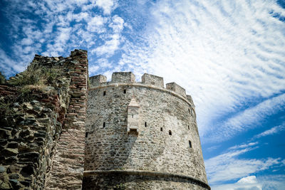 Low angle view of fort against cloudy sky