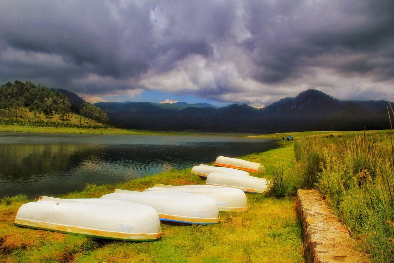 sky, cloud - sky, cloudy, tranquil scene, grass, water, tranquility, scenics, beauty in nature, cloud, nature, landscape, lake, green color, mountain, weather, field, idyllic, overcast, non-urban scene