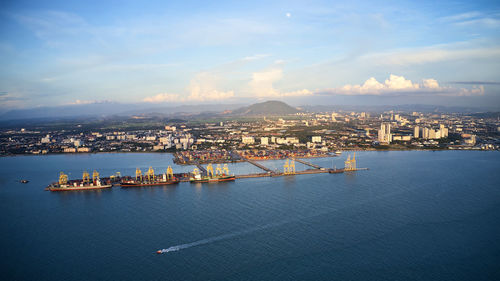 High angle view of cityscape by sea against sky