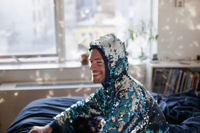 A man smiling in a sequin jacket