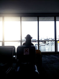 Rear view of man looking at window