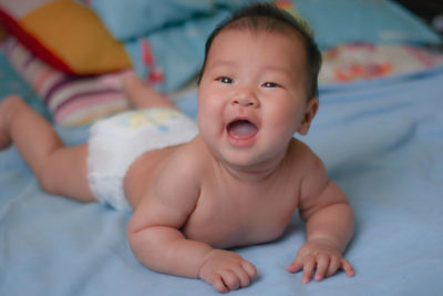 Portrait of cute baby lying on bed