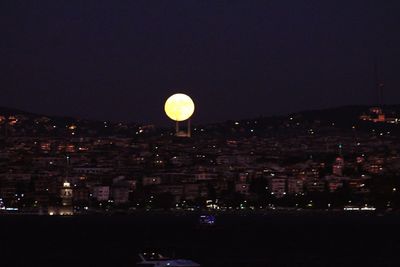 Illuminated cityscape against sky at night