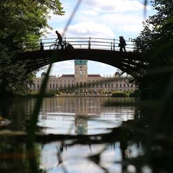 Arch bridge over river against sky