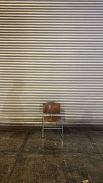 Empty chair against wall