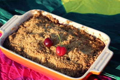 High angle view of cherries on pie in container at table