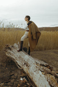 Side view of young man sitting on field