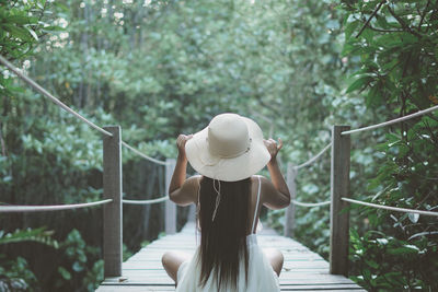 Rear view of woman standing on footbridge