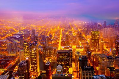 Aerial view of illuminated buildings in city at night