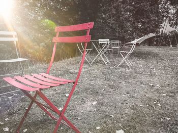 Empty chairs and table on field