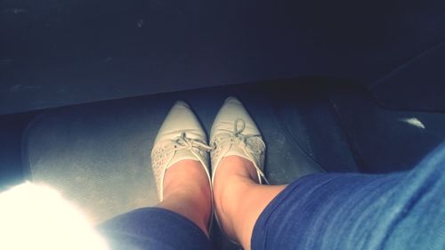 Low section of person wearing shoes in car