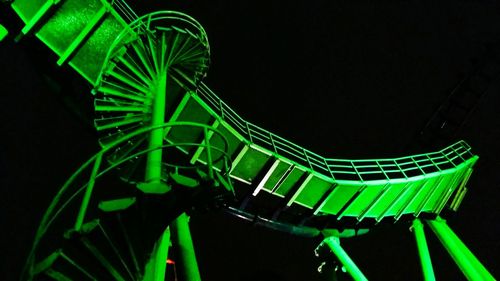 Illuminated ferris wheel against black background