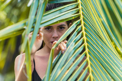 Portrait of woman holding palm leaf