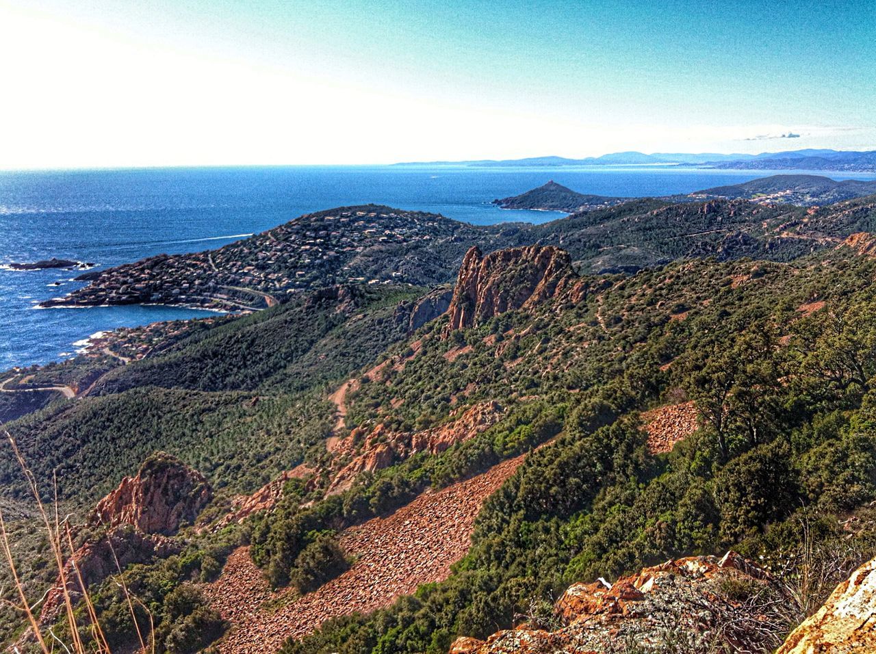 sea, horizon over water, tranquil scene, water, scenics, tranquility, beauty in nature, mountain, high angle view, nature, coastline, clear sky, blue, sky, idyllic, landscape, plant, day, outdoors, beach