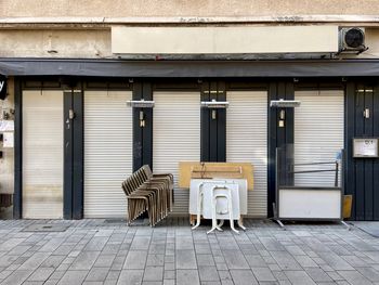 Empty seats on footpath against building