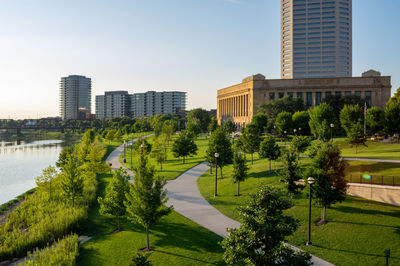 Trees and buildings in city against sky