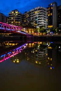 Illuminated bridge over river at night