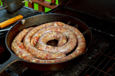 Sausages in cooking pan on barbecue