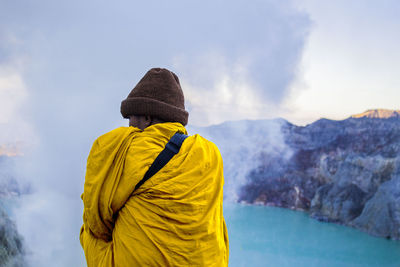 Rear view of man with scarf standing on mountain