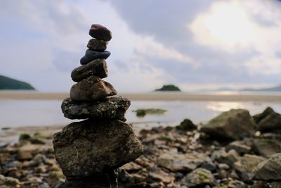 Stack of stones on beach against sky