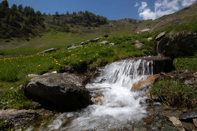 Scenic view of waterfall against sky