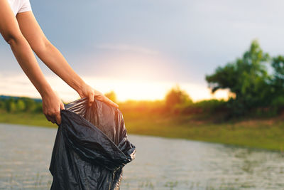 Midsection of woman against sky during sunset