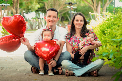 Portrait of smiling family sitting on field