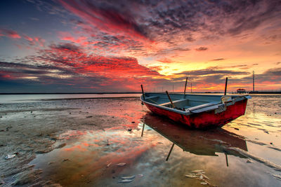 Scenic view of sea against dramatic sky during sunset