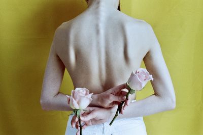 Rear view of a man holding flower head