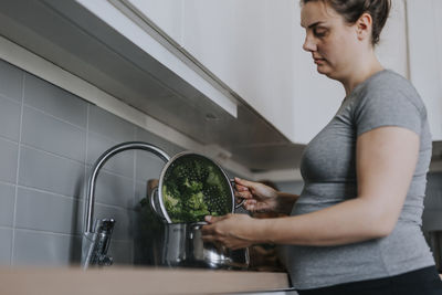 Pregnant woman in kitchen preparing food