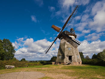 Traditional windmill on field against sky