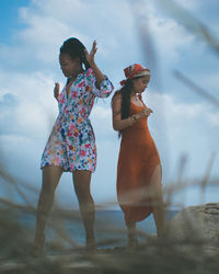 Female friends dancing at beach