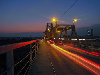 Light trails on road against sky at night