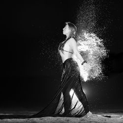 Side view of woman standing by water