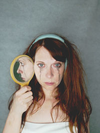 Portrait of smiling young woman blowing bubbles at home