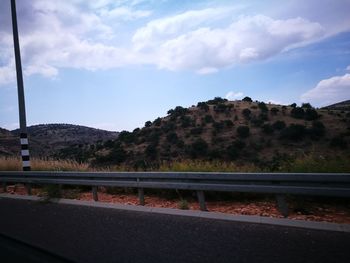 Road by mountain against sky