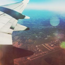 Aerial view of airplane wing over cityscape