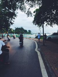 People sitting on road in city