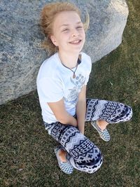 High angle view of smiling girl sitting on grass