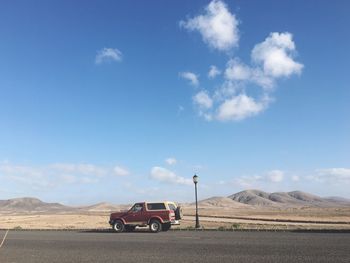 Car on desert against sky