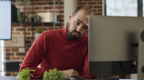 Businessman sitting with head in hand at desk