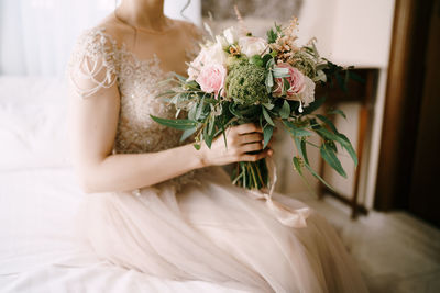 Midsection of woman holding flower bouquet