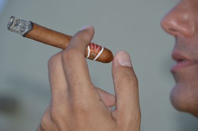 Cropped hand of man smoking cigar