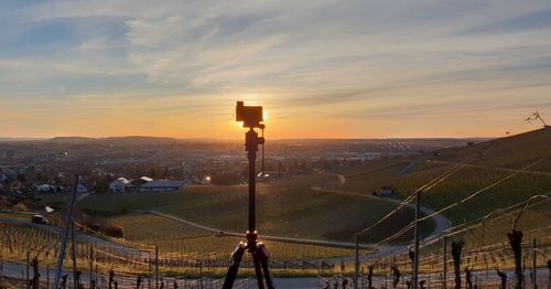 Camera on tripod against landscape during sunset